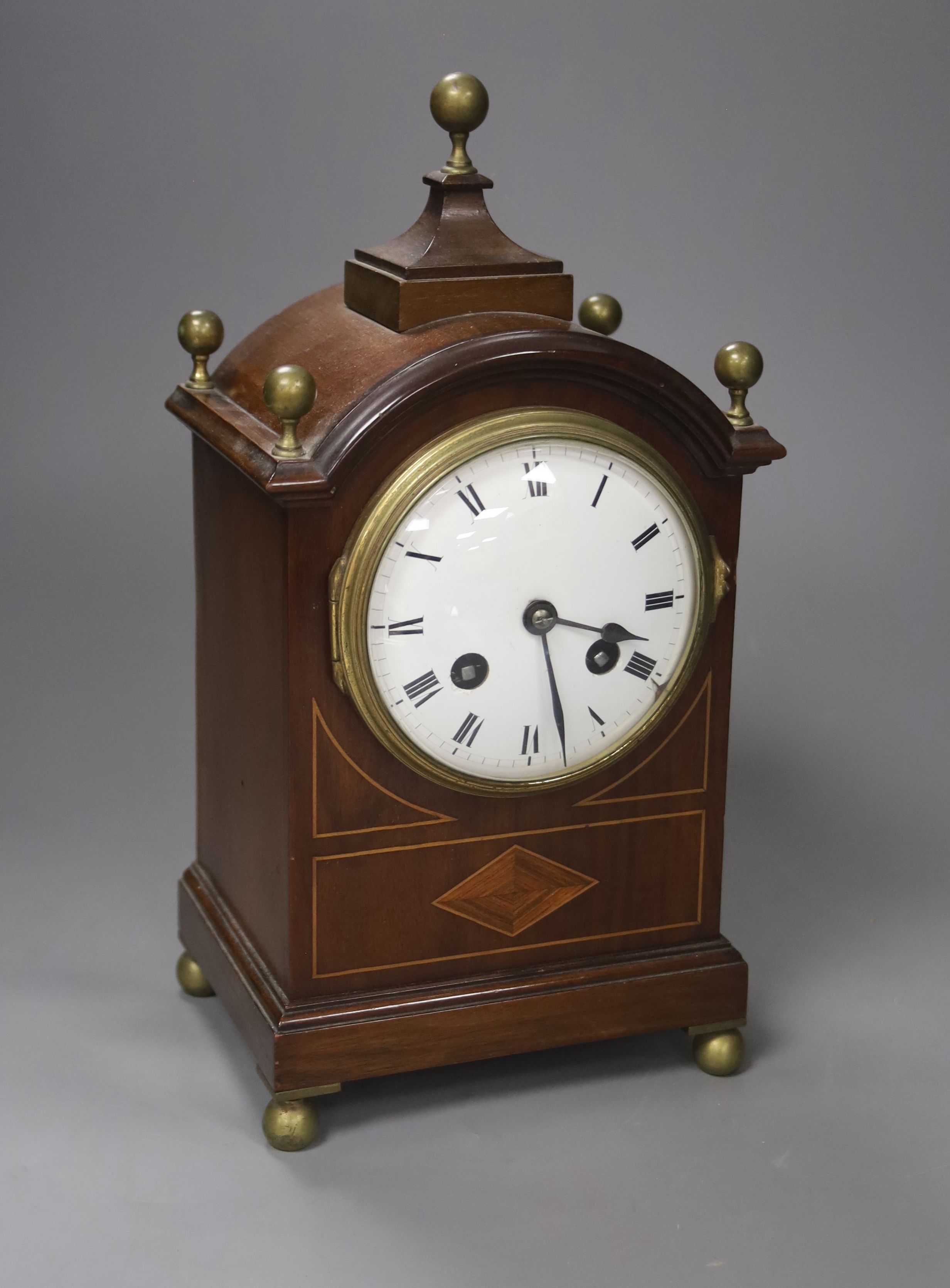 An inlaid mahogany mahogany mantel clock with brass ball finials, height 28cm